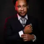 Jordan Mensah, Head of Compliance at Infinite Corporate, portrait in a dark suit with glasses